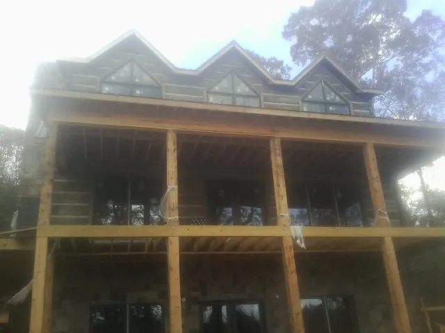 Dormers and porch framing on a large log home under construction — Roof Coating work by our crew in Calhoun Falls