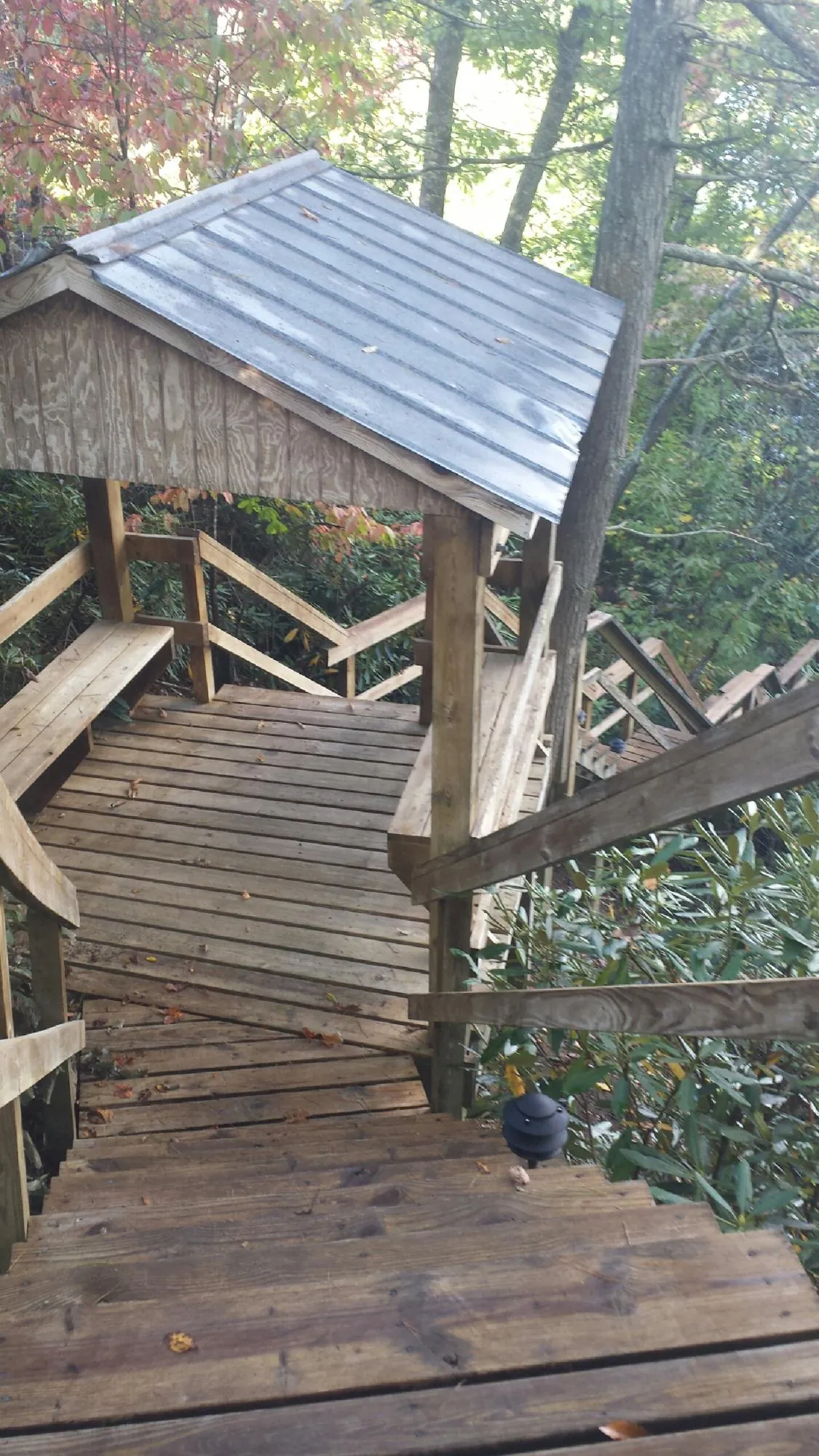 Metal roofed shelter over wooden steps on a wooded walkway — Skylight Repair & Installation work by our crew in Calhoun Falls