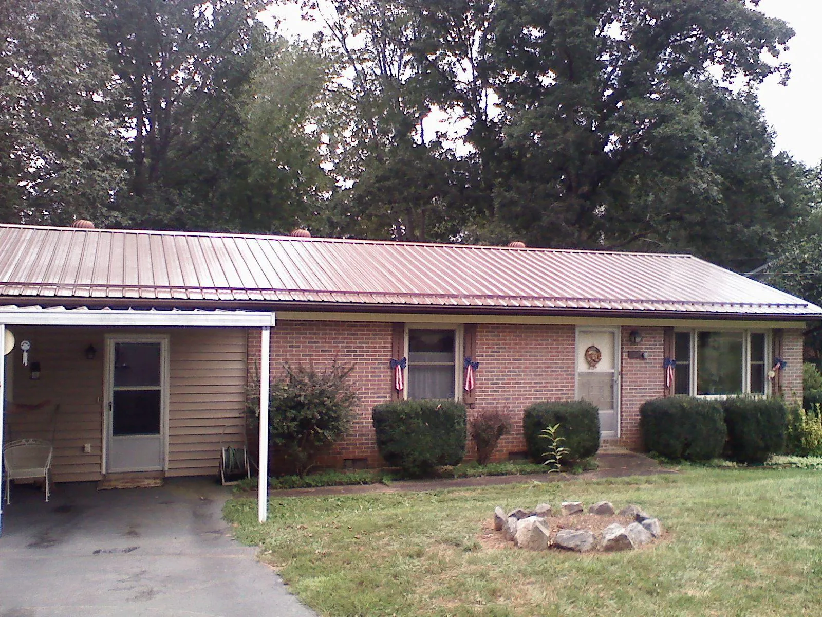 Bronze metal roof and carport on a brick ranch home — Roof Repair work by our crew in Calhoun Falls